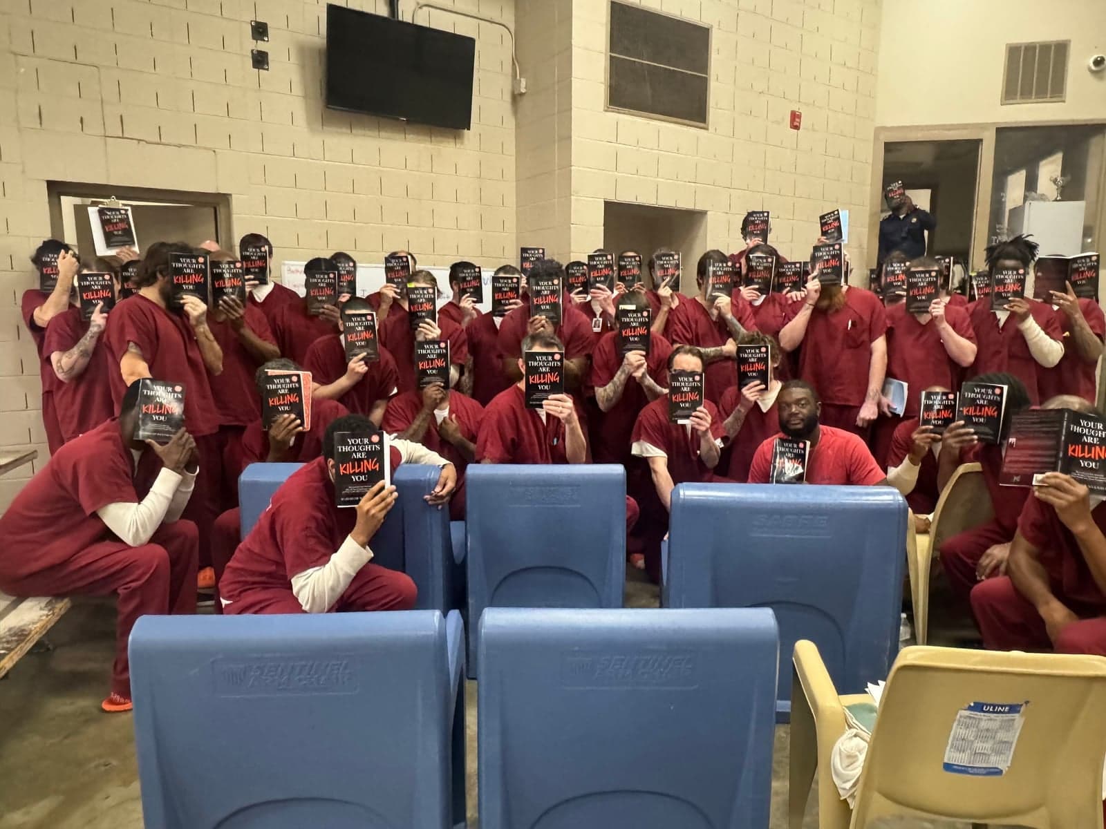 Inmates holding copies of Your Thoughts Are Killing You by Marybeth Wuenschel